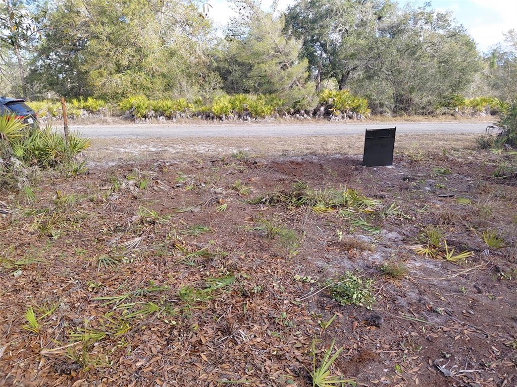 A view of a cleared, sandy lot with sparse vegetation and a black sign — 4311 GARDENIA DRIVE, INDIAN LAKE ESTATES, FL
