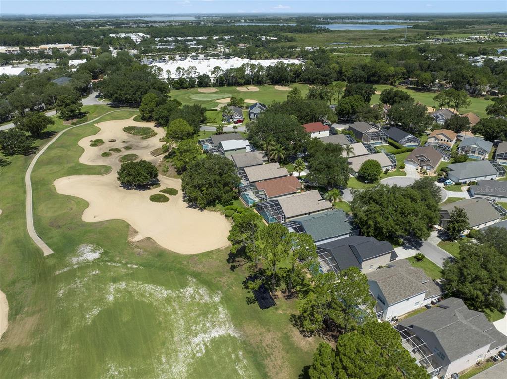 An aerial view shows a residential neighborhood bordering a golf course with sand traps — 2135 MALLORY CIRCLE, HAINES CITY, FL