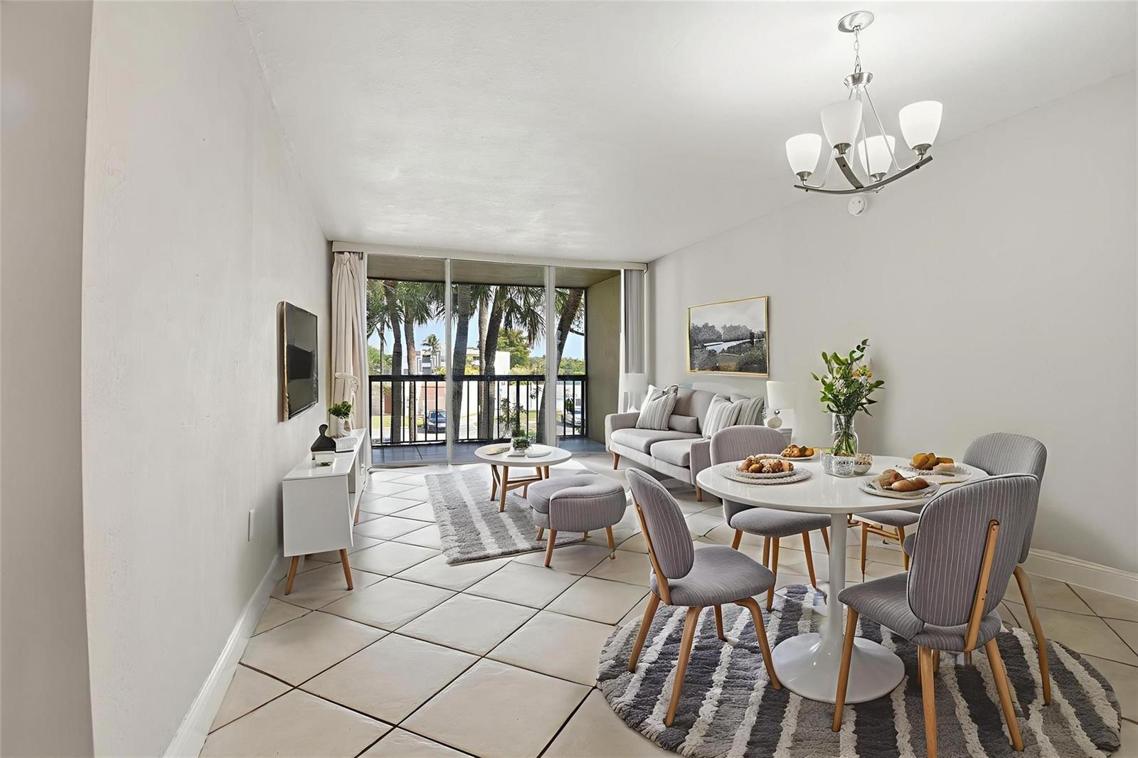 A living and dining area features tiled floors, a balcony, and modern gray furniture — 10875 SW 112th Avenue # 202, Miami FL 33176, MIAMI, FL