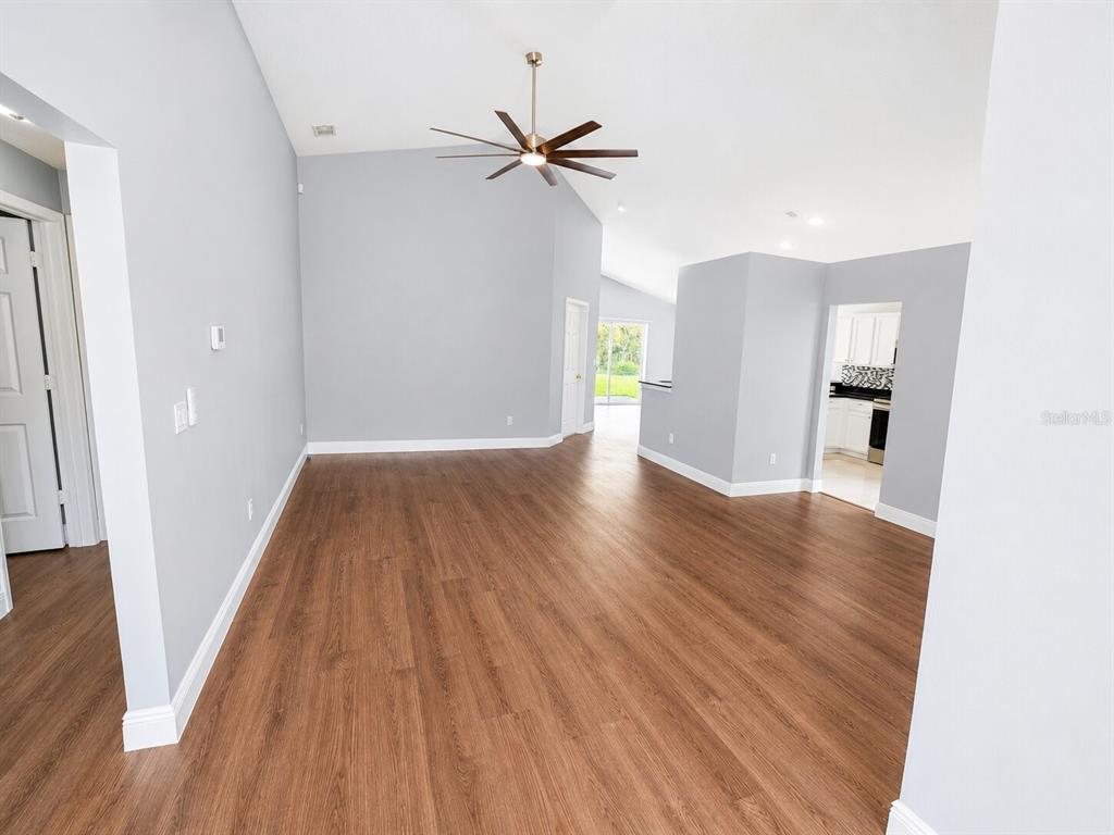 An empty living room features light gray walls, wood-look flooring, and a ceiling fan — 1926 DARLIN CIRCLE, ORLANDO, FL