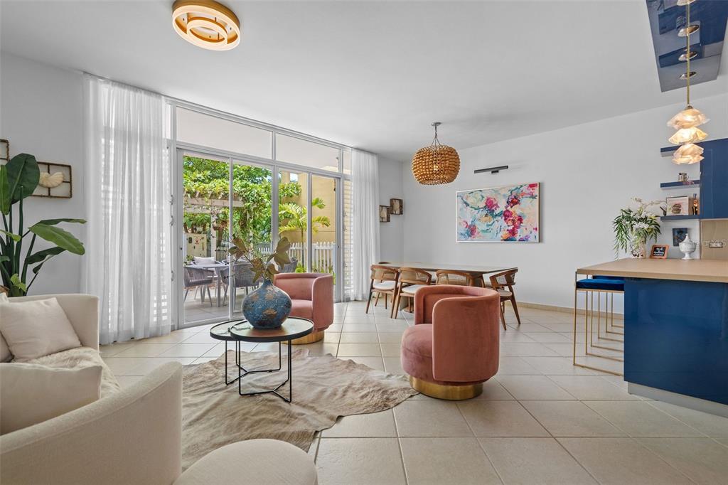 A bright, open-concept living and dining area features tile floors, pink chairs, and sliding doors — 300 HARBOUR DRIVE UNIT A7, HUMACAO, PR