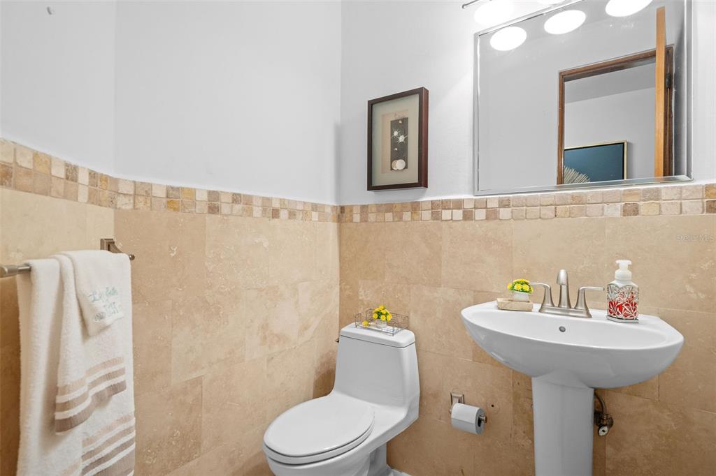 A half bathroom features tan tile walls, a pedestal sink, and a white toilet — 300 HARBOUR DRIVE UNIT A7, HUMACAO, PR