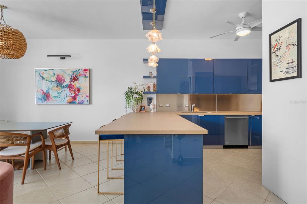 A kitchen features glossy blue cabinets, a beige island countertop, and tile flooring — 300 HARBOUR DRIVE UNIT A7, HUMACAO, PR