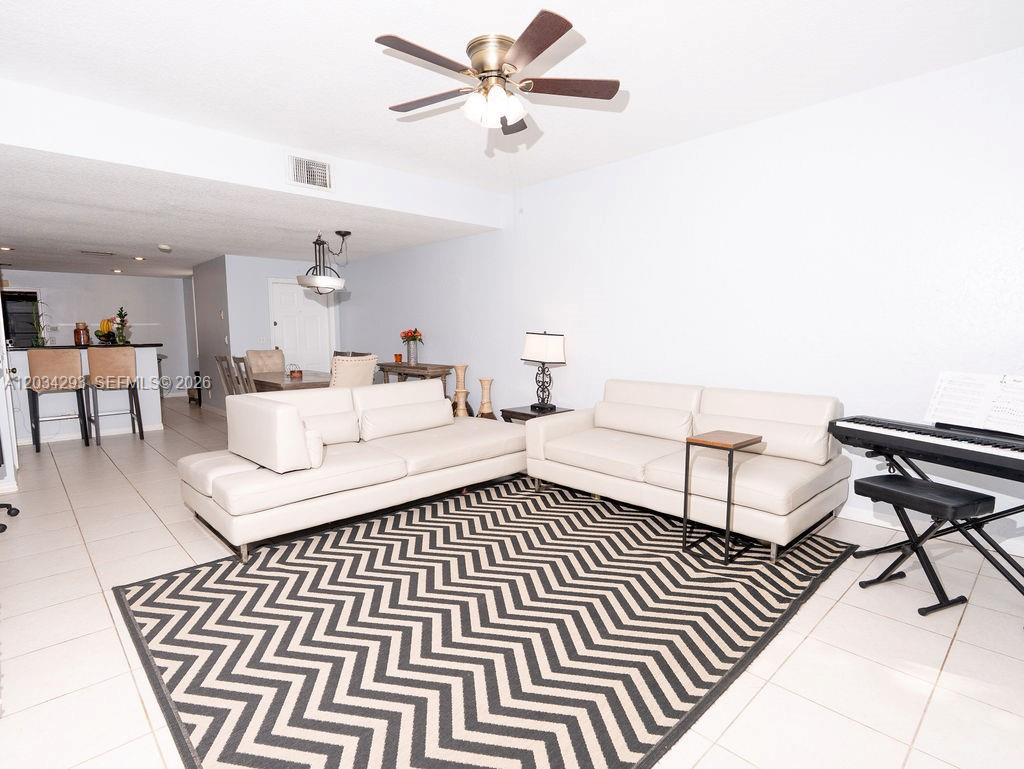 A living room features two white sofas on a chevron rug under a ceiling fan — 1611 Veracruz Ln # 17, Weston FL 33327, WESTON, FL
