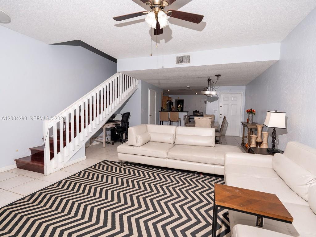 A living room features a white sectional sofa, a chevron rug, and a staircase — 1611 Veracruz Ln # 17, Weston FL 33327, WESTON, FL
