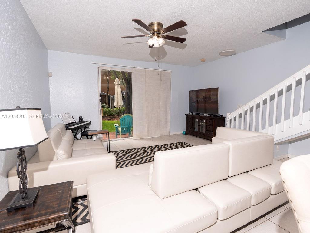 A living room features white leather sofas, a ceiling fan, and a sliding glass door — 1611 Veracruz Ln # 17, Weston FL 33327, WESTON, FL