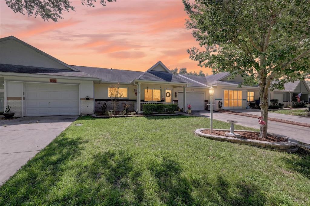 A single-story duplex with a front lawn, a tree, and two attached garages — 9690 SW 95TH TERRACE UNIT B, OCALA, FL