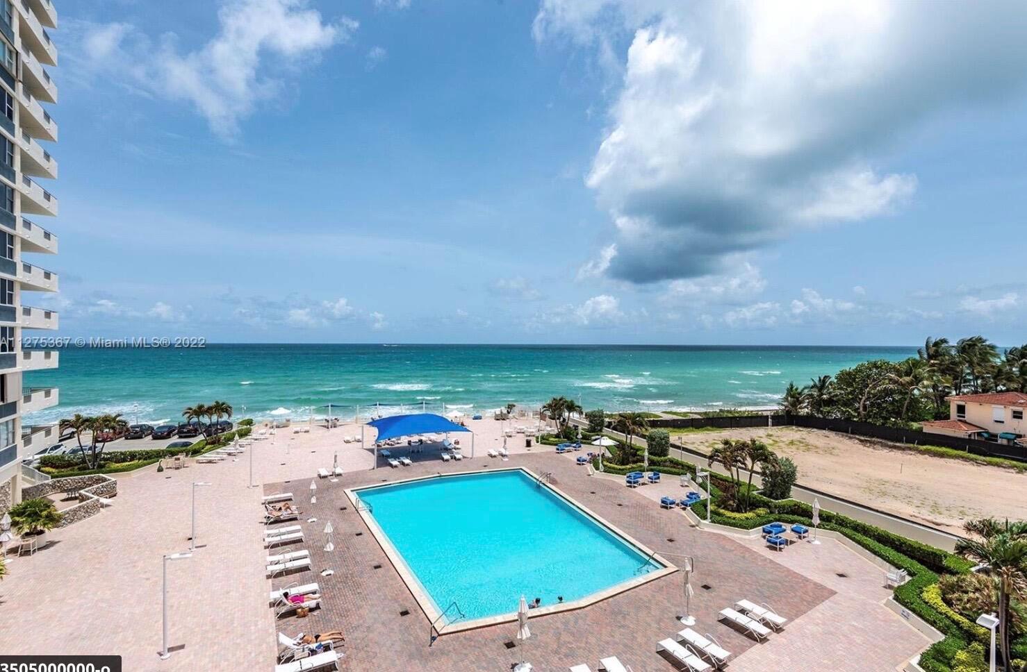 An elevated view shows a swimming pool on a patio overlooking the ocean beach — 3180 S Ocean Drive # 414, Hallandale Beach FL 33009, HALLANDALE BEACH, FL