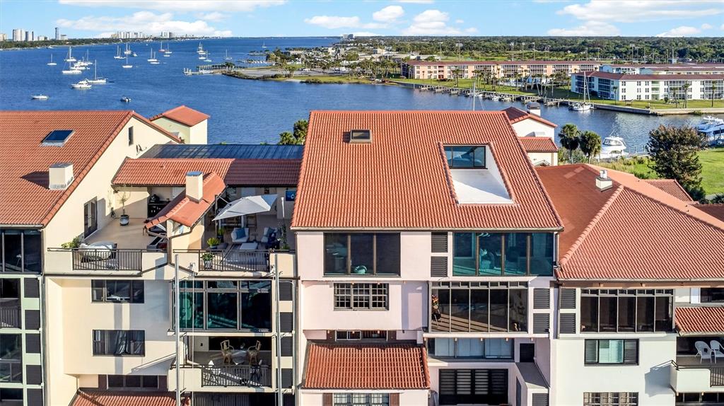 An aerial view shows the exterior of a multi-story waterfront condominium complex with tiled roofs — 661 MARINA POINT DRIVE UNIT 661, DAYTONA BEACH, FL