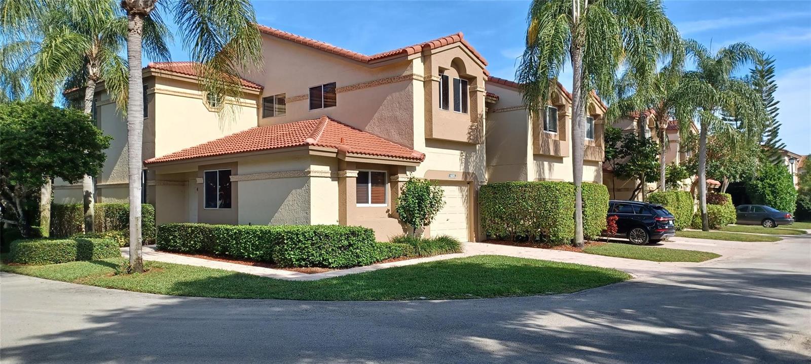 A two-story townhouse with a tan stucco exterior, red tile roof, and a single-car garage — 6688 Via Regina, Boca Raton FL 33433, BOCA RATON, FL