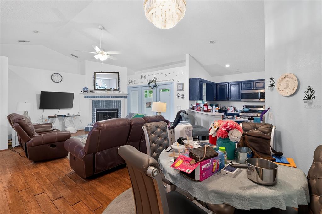 A living room with a fireplace and brown leather furniture flows into a dining area — 4353 DINNER LAKE DRIVE, LAKE WALES, FL