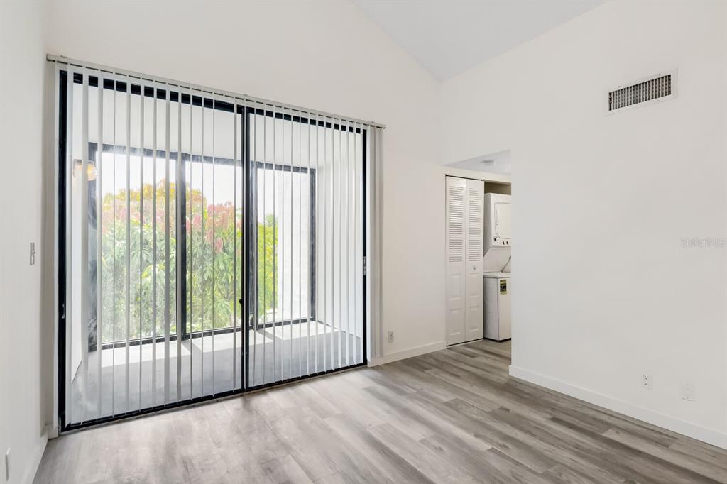 A room with light wood-look flooring, white walls, vertical blinds, and a laundry closet — 210 LAKE POINTE CONDO FIVE DRIVE UNIT 304, OAKLAND PARK, FL