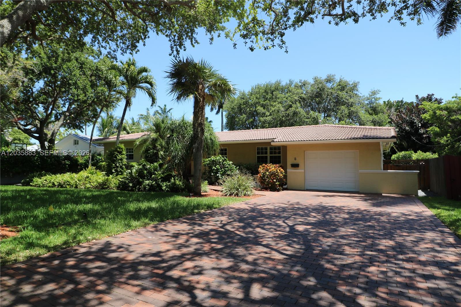 A single-story house with a tiled roof, a brick driveway, and palm trees in front — 6160 SW 84th St, South Miami FL 33143, SOUTH MIAMI, FL