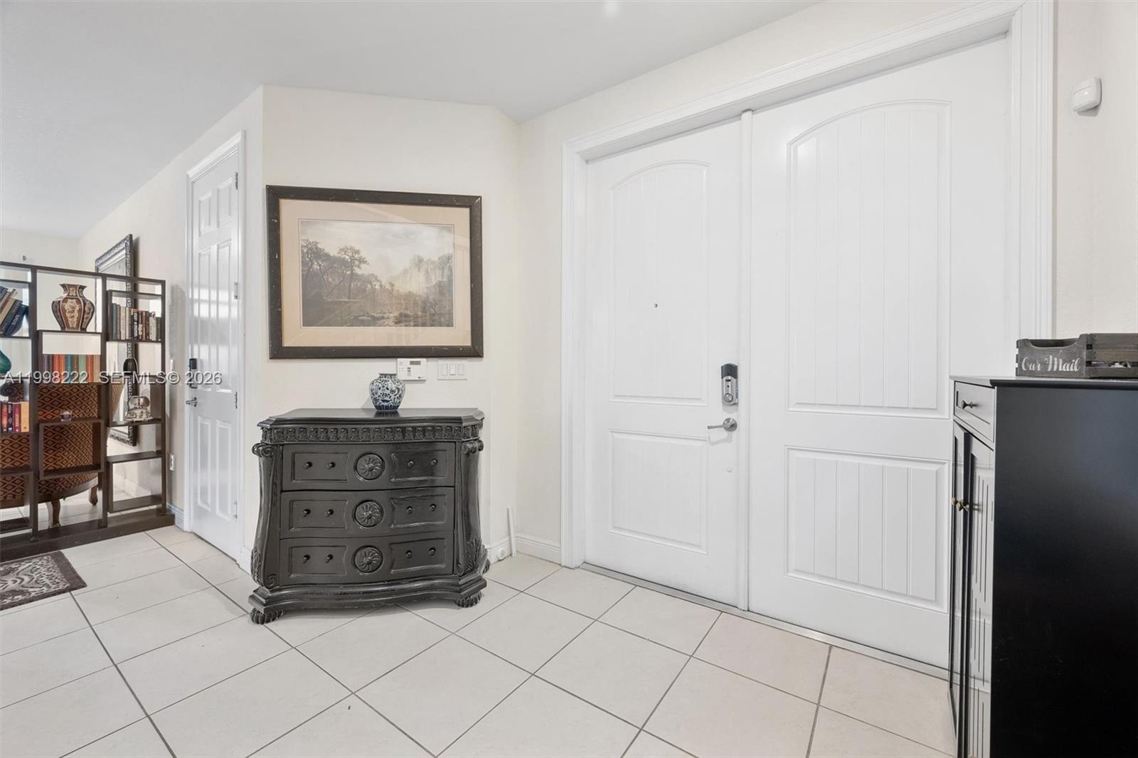 An entryway features white double doors, a black chest of drawers, and tiled flooring — 8755 NW 102nd Ct, Doral FL 33178, DORAL, FL
