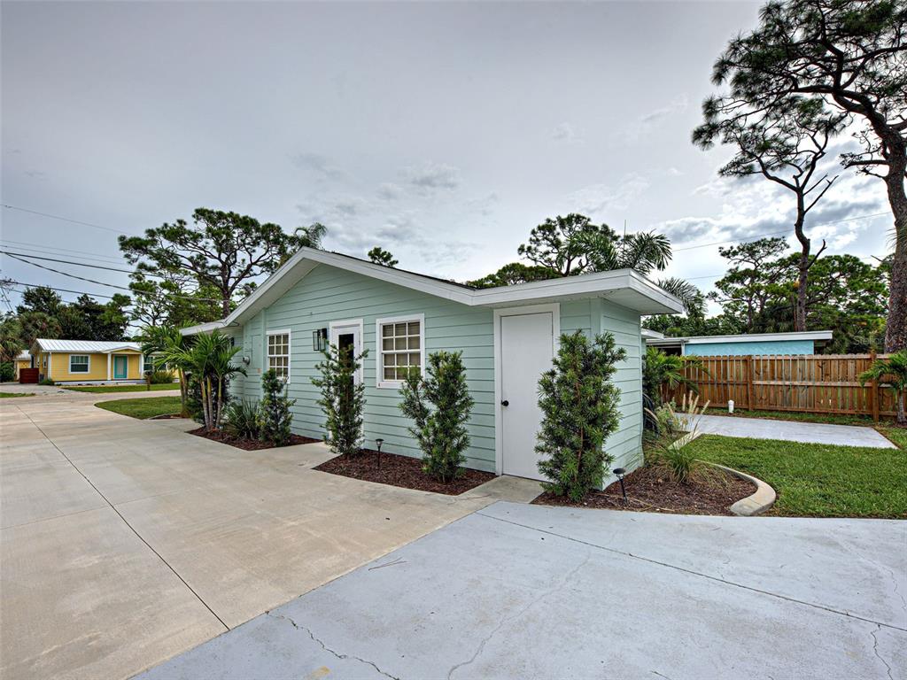 A light green exterior building with a white door and windows sits on a concrete lot — 415 YALE STREET, ENGLEWOOD, FL