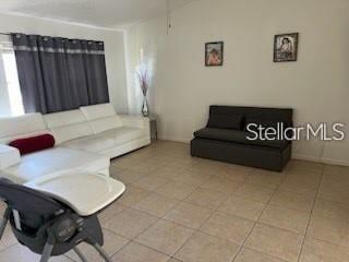 A living room features white tile floors, a white sectional sofa, and a dark loveseat — 124 E 17TH STREET, ST CLOUD, FL