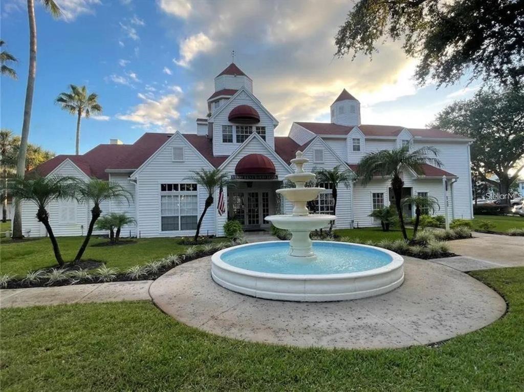 A white building with a red roof and a tiered fountain in the front yard — 11582 WESTWOOD BOULEVARD UNIT 1428, ORLANDO, FL