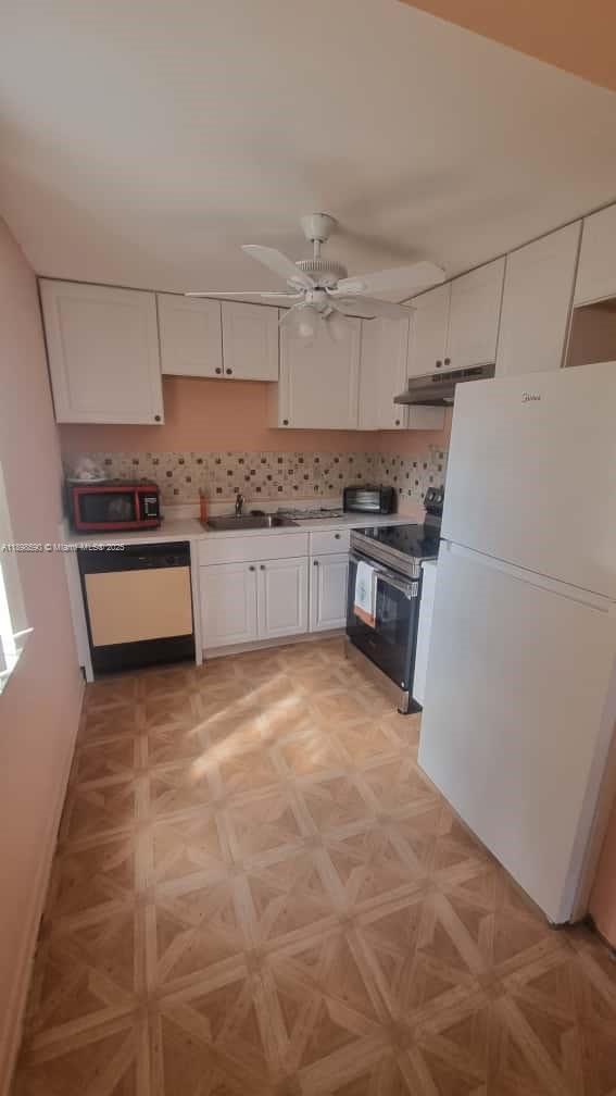 A kitchen features white cabinets, a white refrigerator, a dishwasher, and a patterned tile floor — 176 Piedmont D # D, Delray Beach FL 33484, DELRAY BEACH, FL