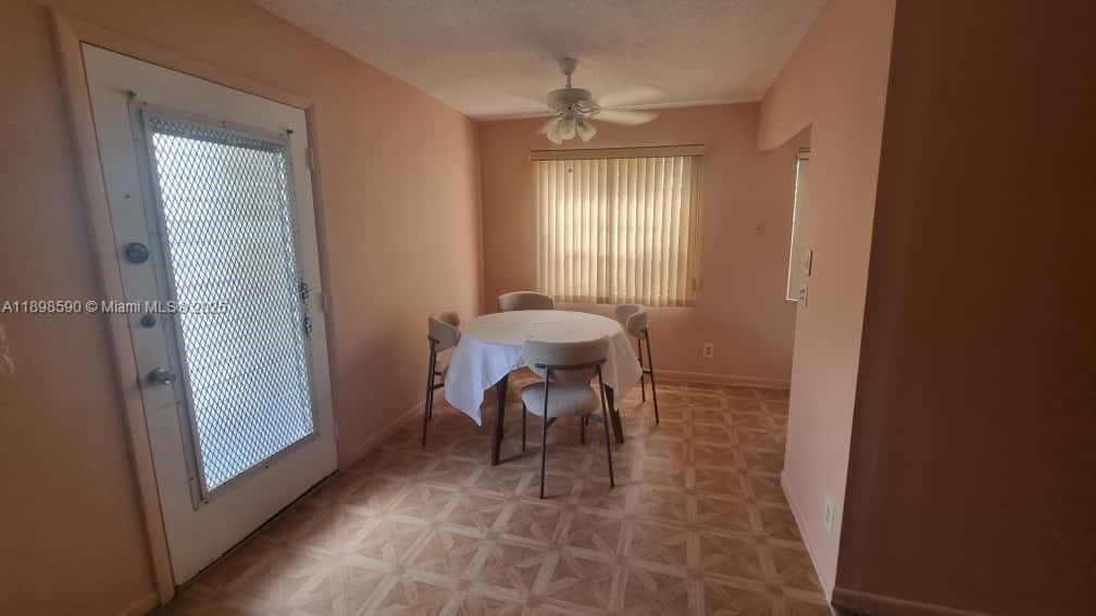 A dining area features a round table with chairs, a ceiling fan, and tiled flooring — 176 Piedmont D # D, Delray Beach FL 33484, DELRAY BEACH, FL