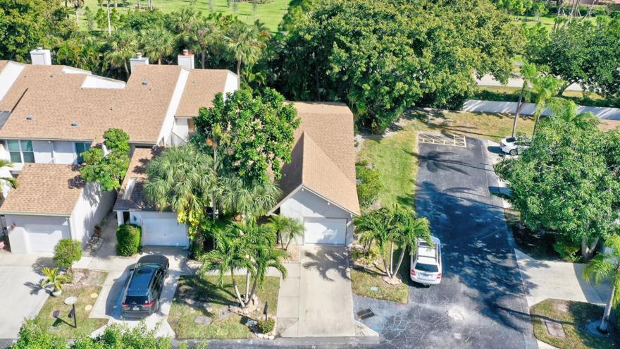 An aerial view shows two attached houses with brown roofs, garages, and surrounding palm trees — 6660 Canary Palm Circle, Boca Raton FL 33433, BOCA RATON, FL