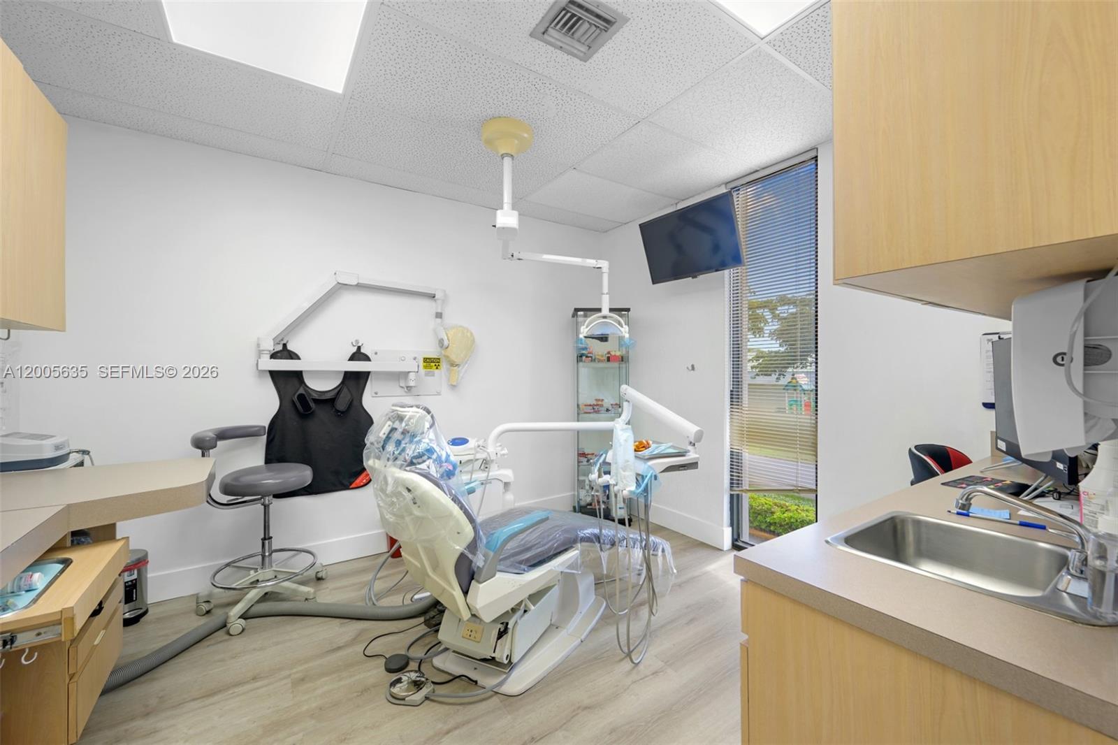 A dental examination room features a patient chair, medical equipment, a sink, and a window — PEMBROKE PINES, FL
