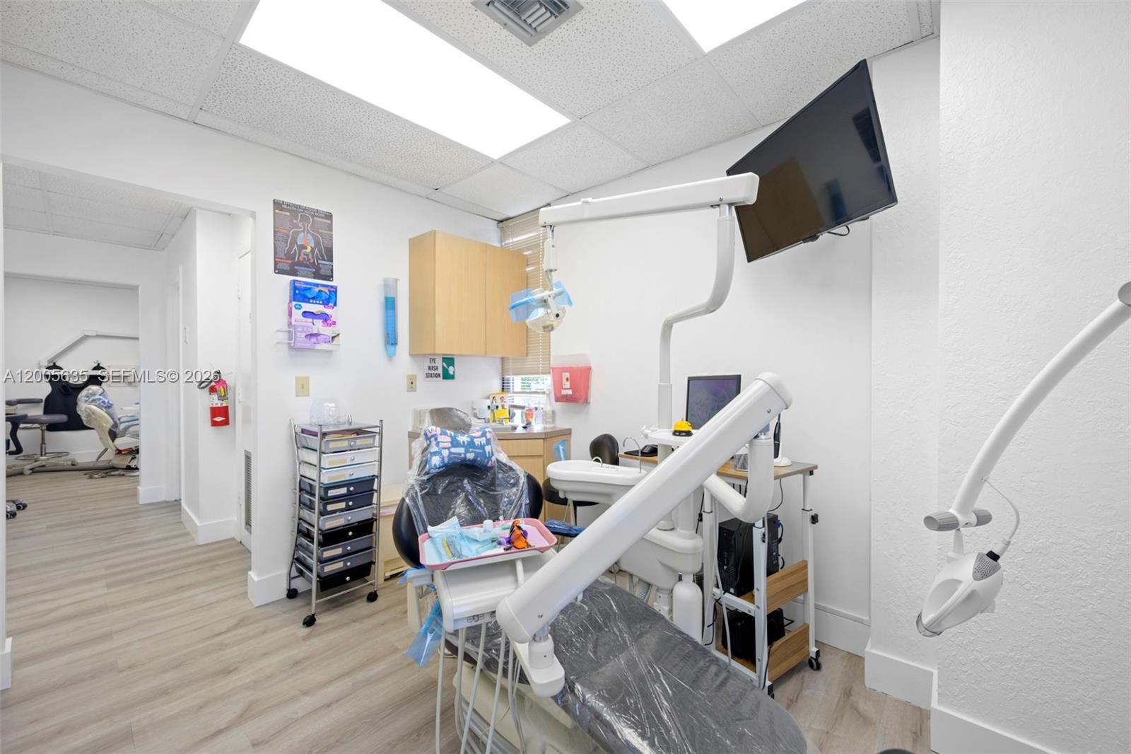 This dental examination room features a patient chair, medical equipment, and light-colored wood flooring — PEMBROKE PINES, FL