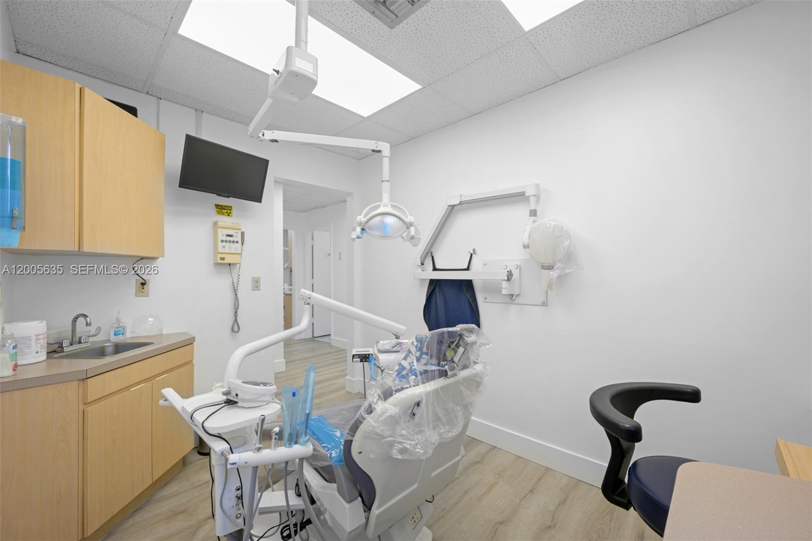 A dental examination room features a patient chair, medical equipment, cabinetry, and a sink — PEMBROKE PINES, FL