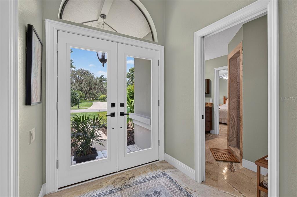 An entryway features double glass doors, light green walls, and marble flooring — 2604 ROYAL LIVERPOOL DRIVE, TARPON SPRINGS, FL