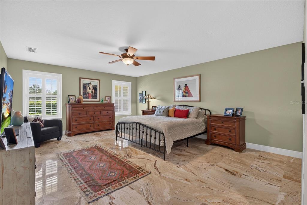 A living room with a fireplace, wicker furniture, tile floors, and a vaulted ceiling — 2604 ROYAL LIVERPOOL DRIVE, TARPON SPRINGS, FL