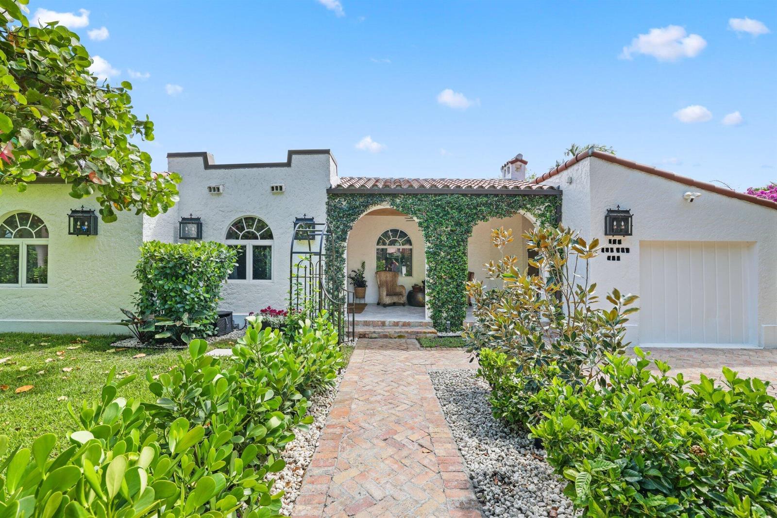 A white stucco house with a vine-covered arched entryway and a brick walkway — 706 Sunset Road, West Palm Beach FL 33401, WEST PALM BEACH, FL