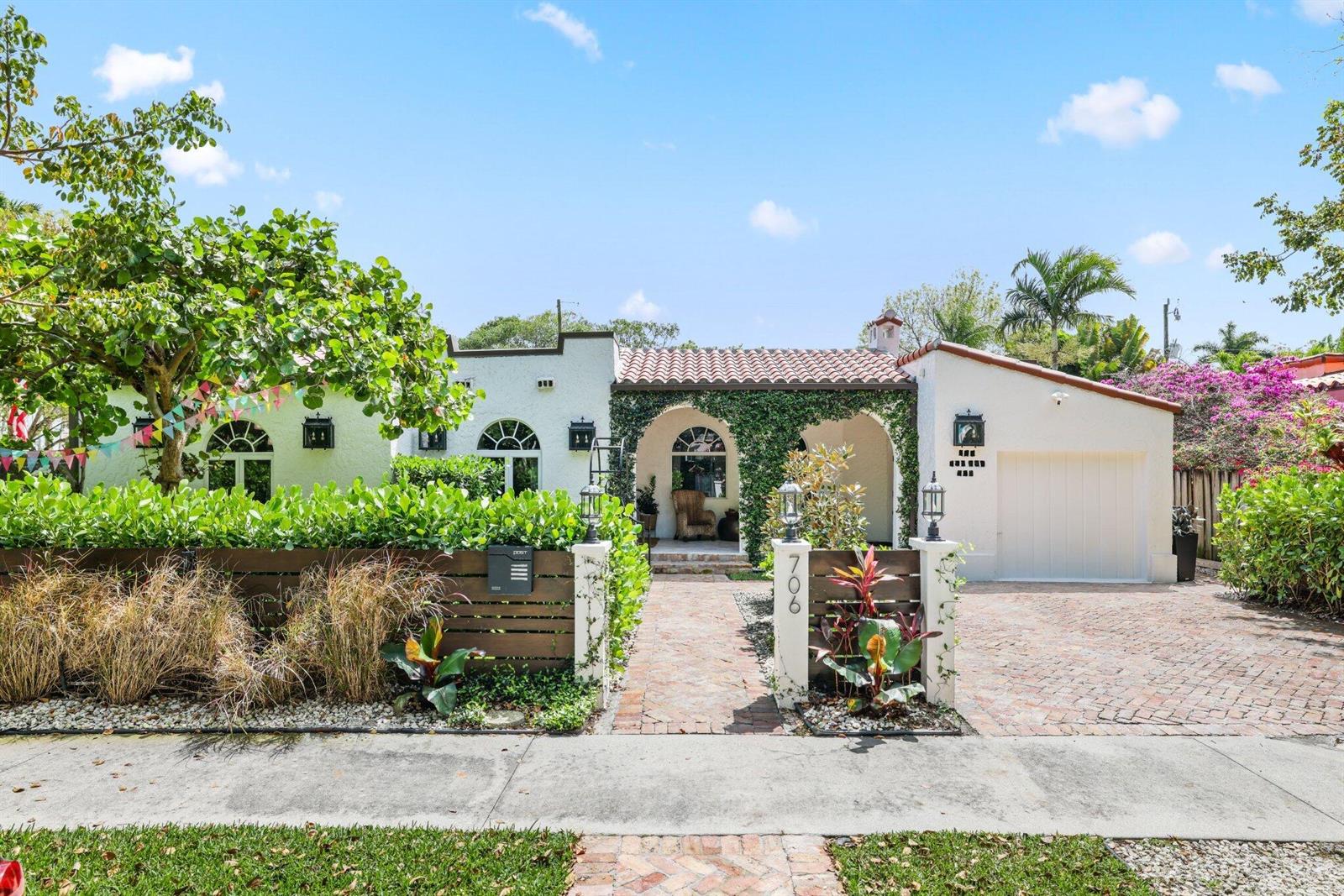 A white stucco house with a tiled roof, arched entryway, and a brick driveway — 706 Sunset Road, West Palm Beach FL 33401, WEST PALM BEACH, FL