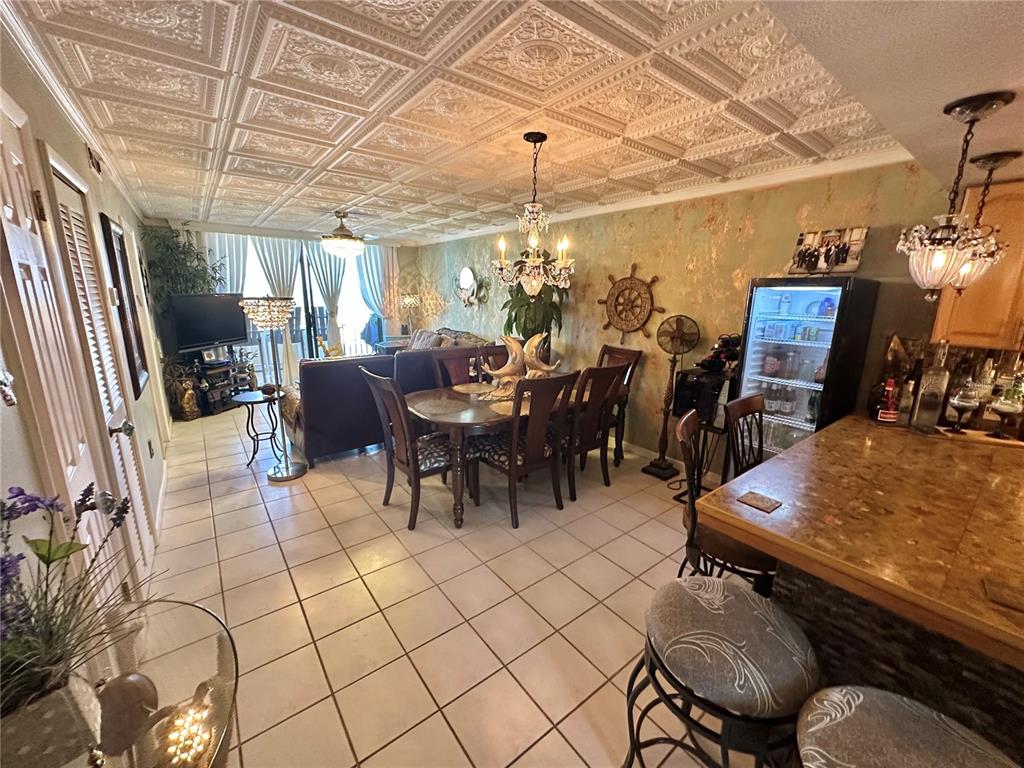 A kitchen features light wood cabinets, a stone-tiled breakfast bar, and a stainless steel refrigerator — 6009 SEA RANCH DRIVE UNIT 108, HUDSON, FL