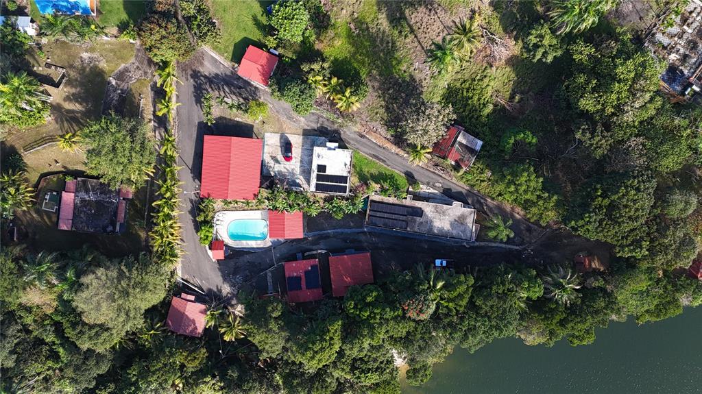Aerial view of a property featuring multiple buildings, a swimming pool, and surrounding lush vegetation — KM 22.1 CARR 119, SAN SEBASTIAN, PR