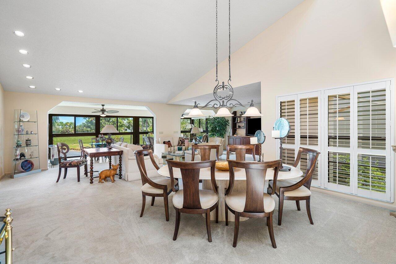 A dining area with a round table and chairs sits in an open-concept living space — 69 Eastgate Drive Unit D, Boynton Beach FL 33436, BOYNTON BEACH, FL