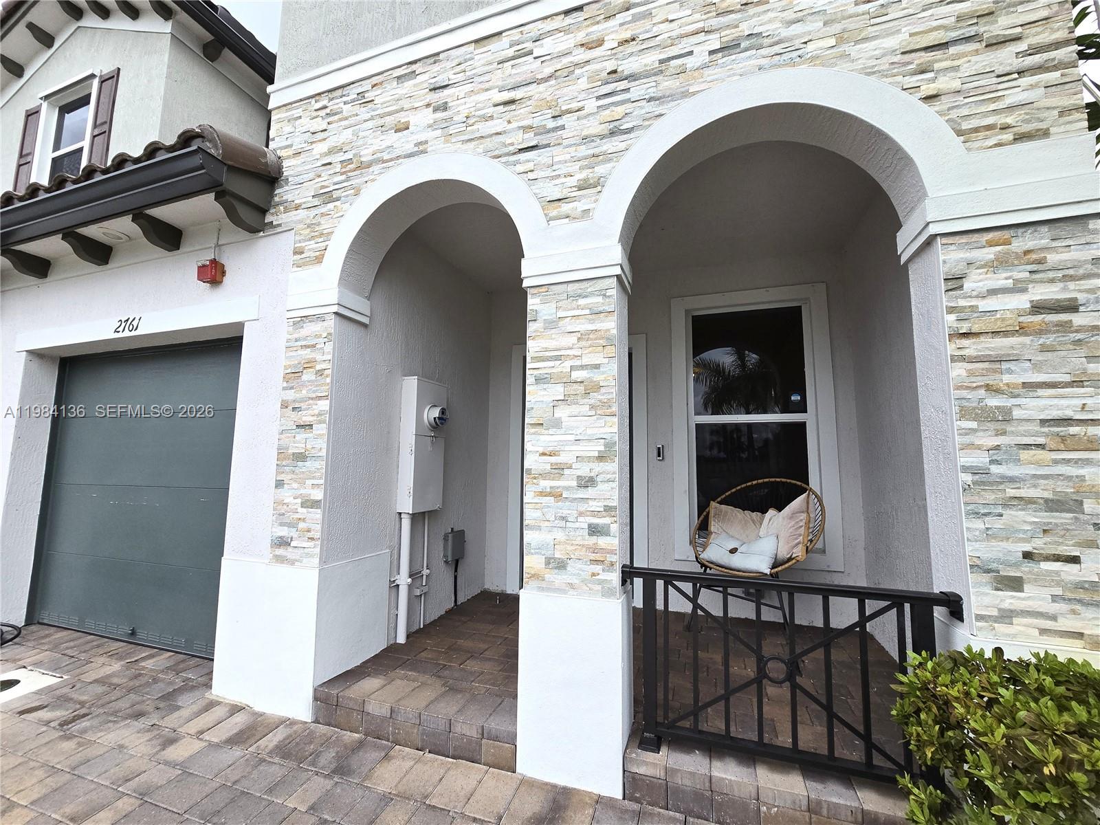 The exterior of a house features a stone-accented facade, two arched entryways, and a garage — 2761 NW 55th Way, Lauderhill FL 33313, LAUDERHILL, FL