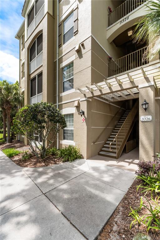 An exterior view of a multi-story apartment building featuring a staircase and a pergola — 3326 ROBERT TRENT JONES DRIVE UNIT 30102, ORLANDO, FL