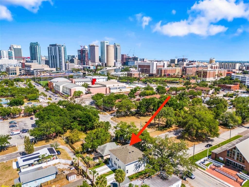 An aerial view shows a white house with a gray roof surrounded by trees — 1005 W CYPRESS STREET UNIT 1, TAMPA, FL