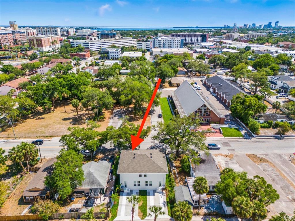 An aerial view shows a white two-story house with a red arrow pointing toward it — 1005 W CYPRESS STREET UNIT 1, TAMPA, FL