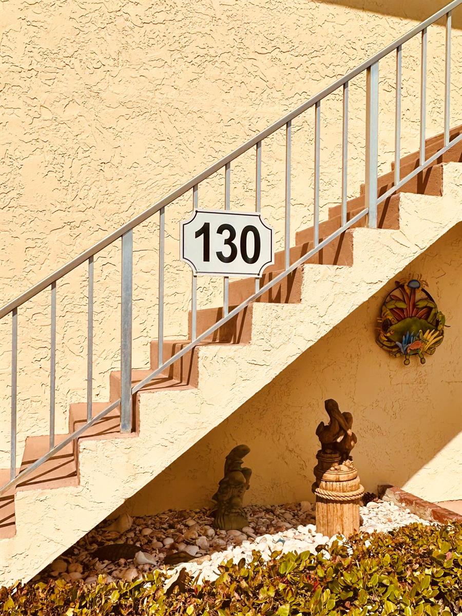 An exterior view shows a staircase with a metal railing and a house number 130 sign — 2950 SE Ocean Boulevard # 6, Stuart FL 34996, STUART, FL