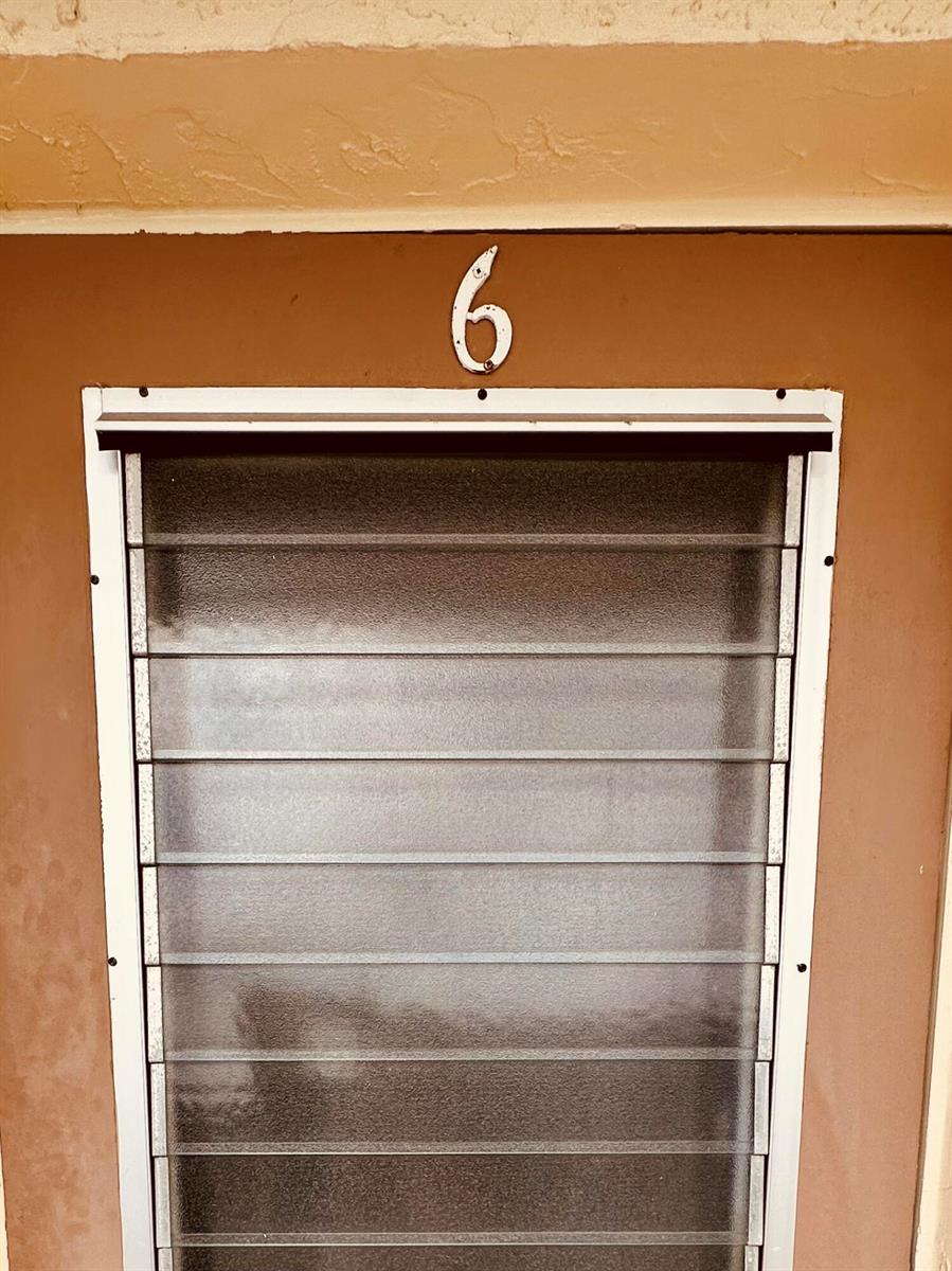 A brown door features a white number six above a glass jalousie window — 2950 SE Ocean Boulevard # 6, Stuart FL 34996, STUART, FL