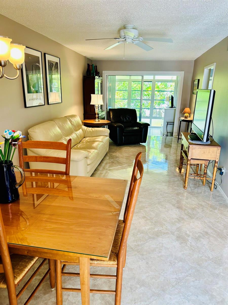 A living and dining area features tile floors, a cream sofa, and a glass-topped table — 2950 SE Ocean Boulevard # 6, Stuart FL 34996, STUART, FL