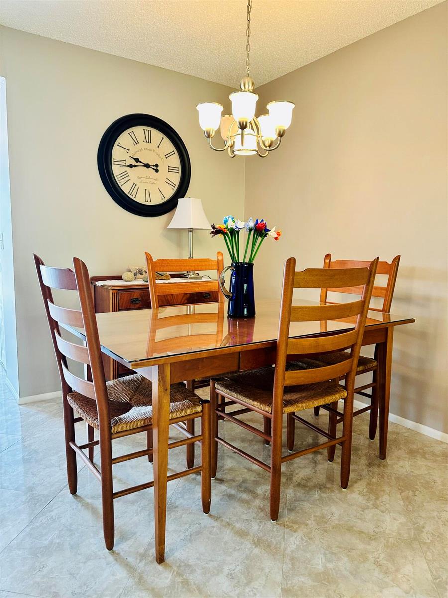 This living and dining area features neutral walls, tile flooring, and a sliding glass door — 2950 SE Ocean Boulevard # 6, Stuart FL 34996, STUART, FL