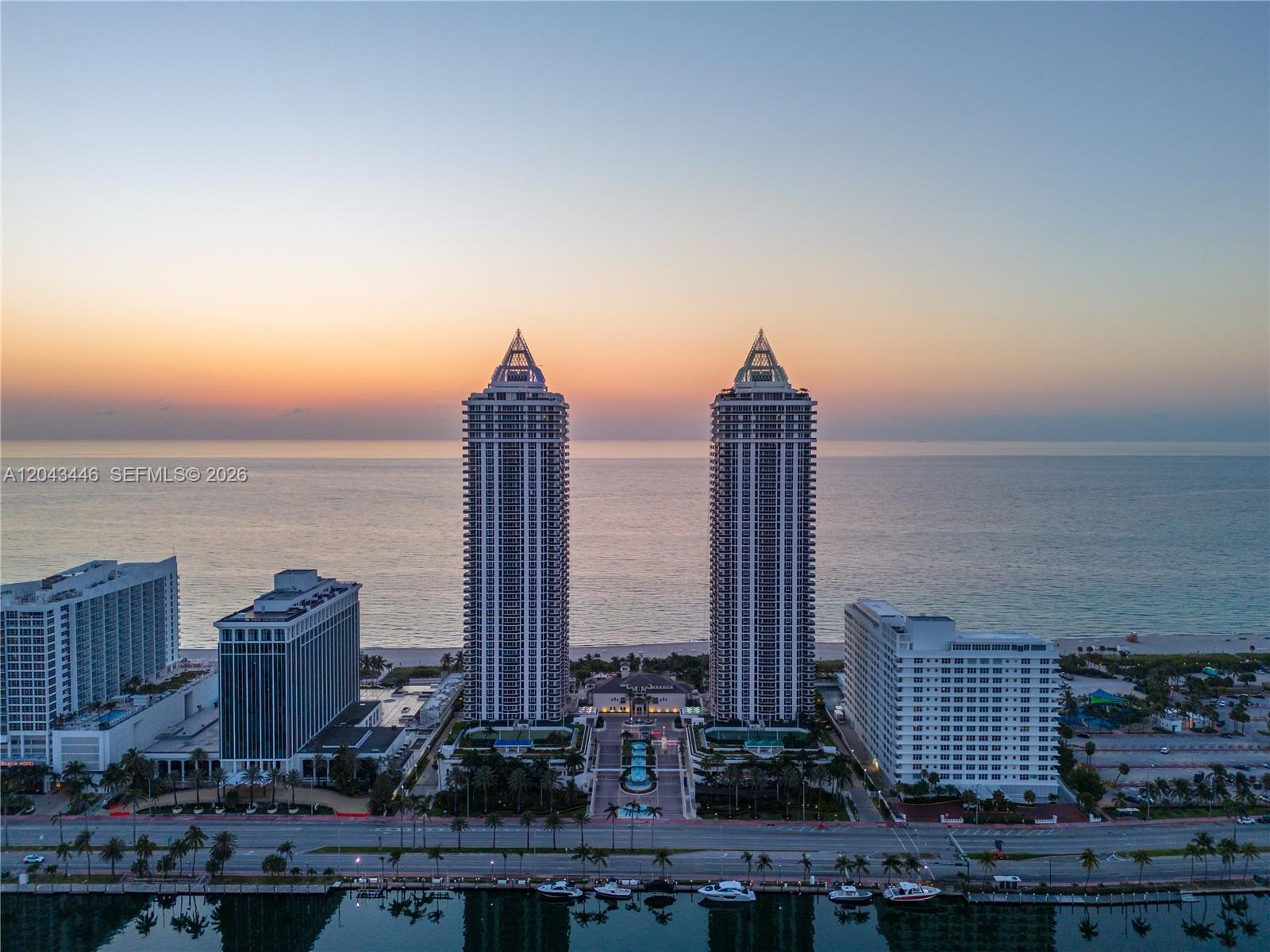 An aerial view shows two tall residential towers situated between a road and the ocean — 4779 Collins Ave, Miami Beach FL 33140, MIAMI BEACH, FL