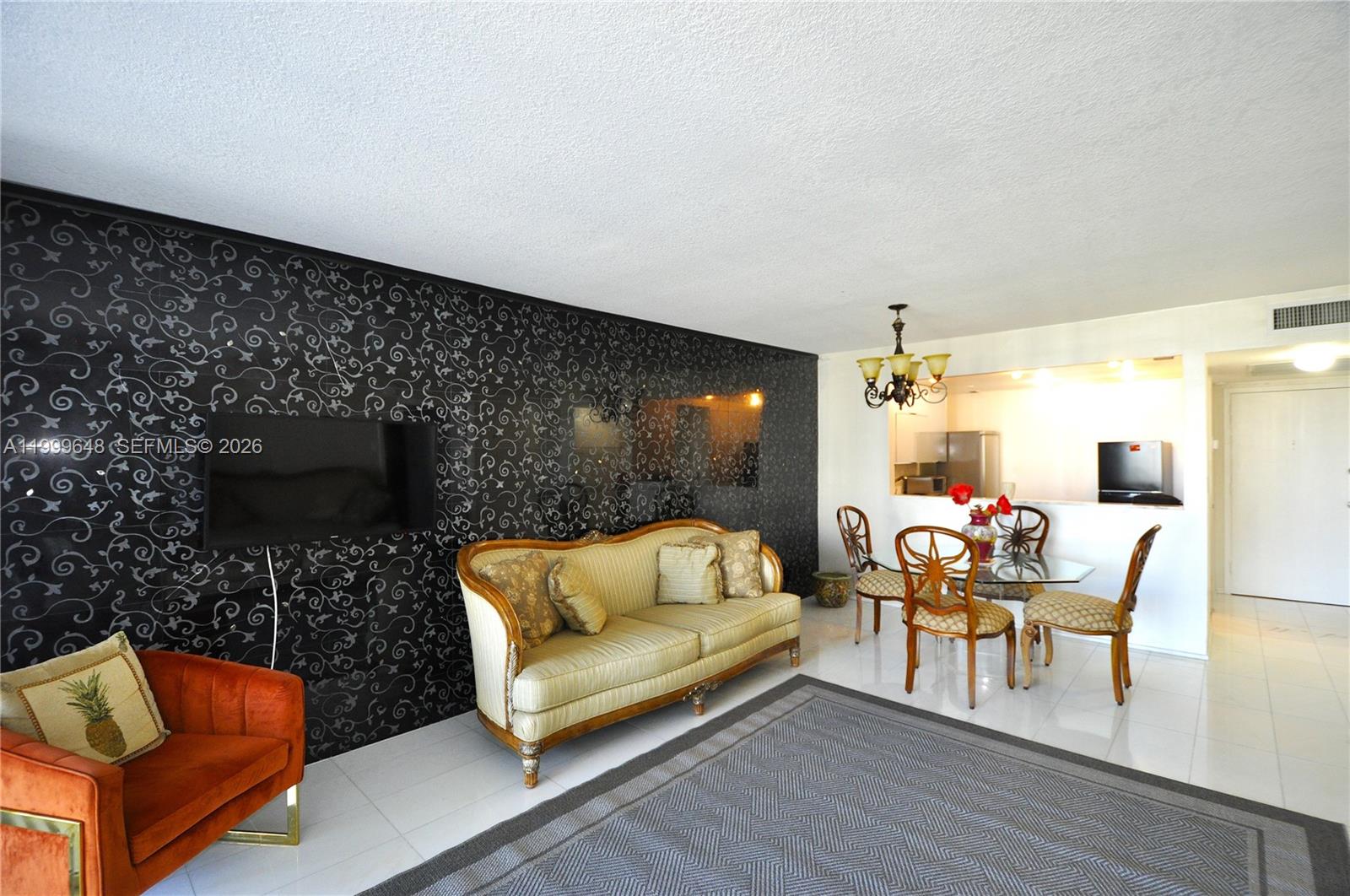 A living and dining area features a black patterned accent wall and white tile flooring — 2030 S Ocean Dr # 803, Hallandale Beach FL 33009, HALLANDALE BEACH, FL