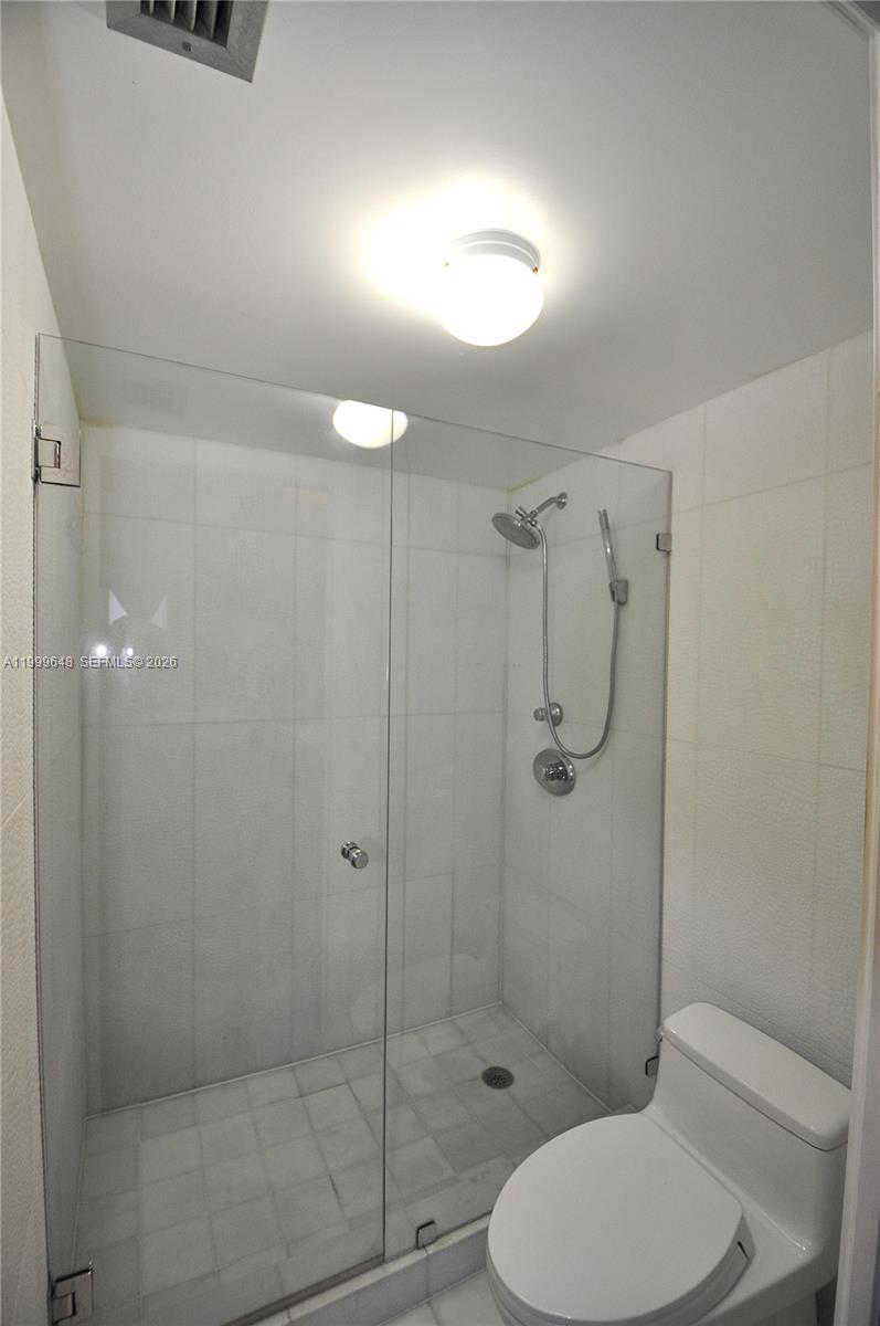 A bathroom features a glass-enclosed walk-in shower with white tile walls and a toilet — 2030 S Ocean Dr # 803, Hallandale Beach FL 33009, HALLANDALE BEACH, FL