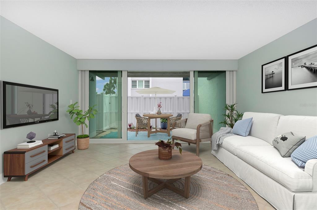 A living room with a white sofa, round coffee table, and sliding doors to a patio — 450 TREASURE ISLAND CAUSEWAY UNIT 105, TREASURE ISLAND, FL