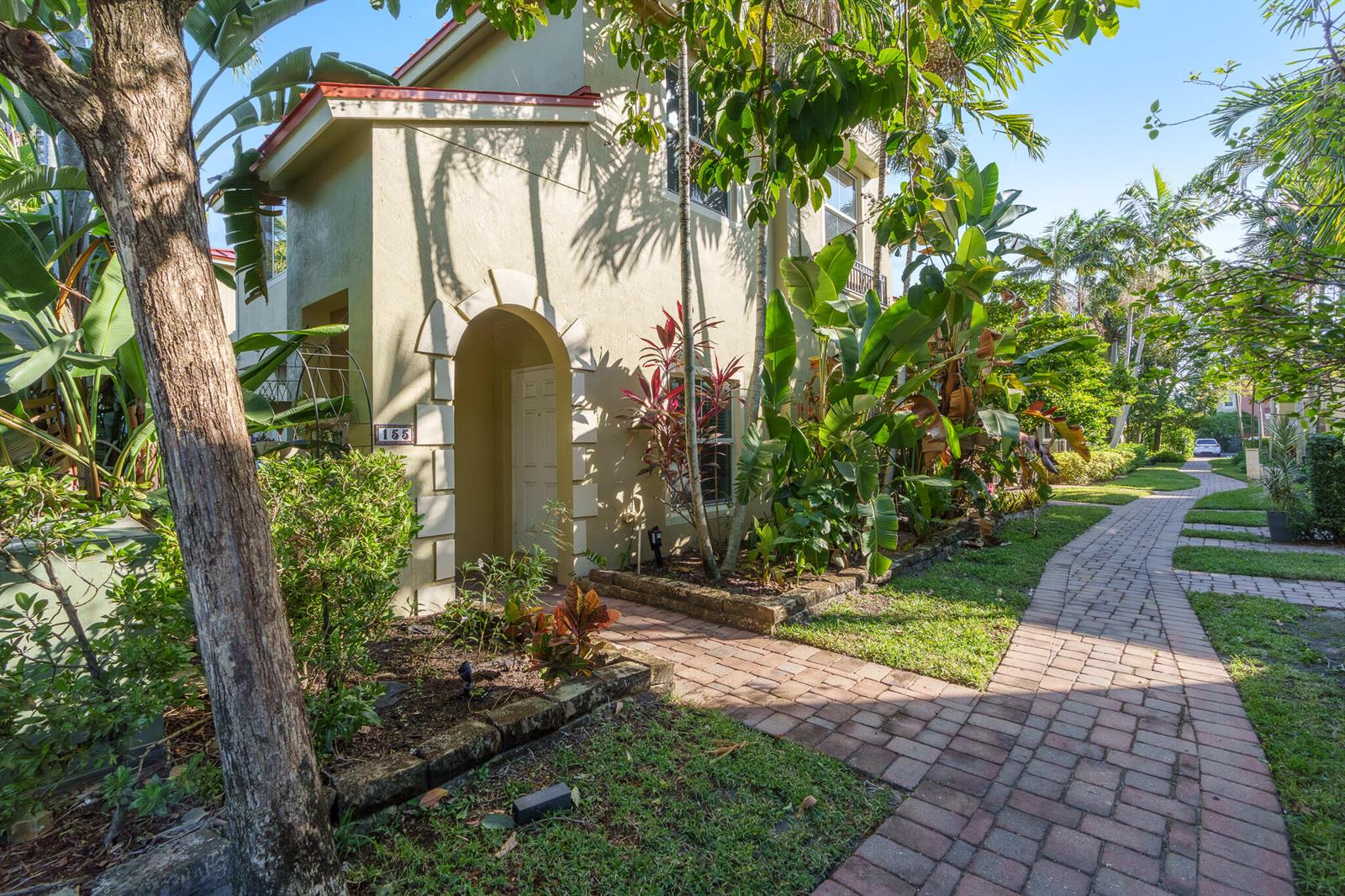 A two-story tan stucco building with an arched entryway and a brick walkway — 155 Monterey Bay Drive, Boynton Beach FL 33426, BOYNTON BEACH, FL