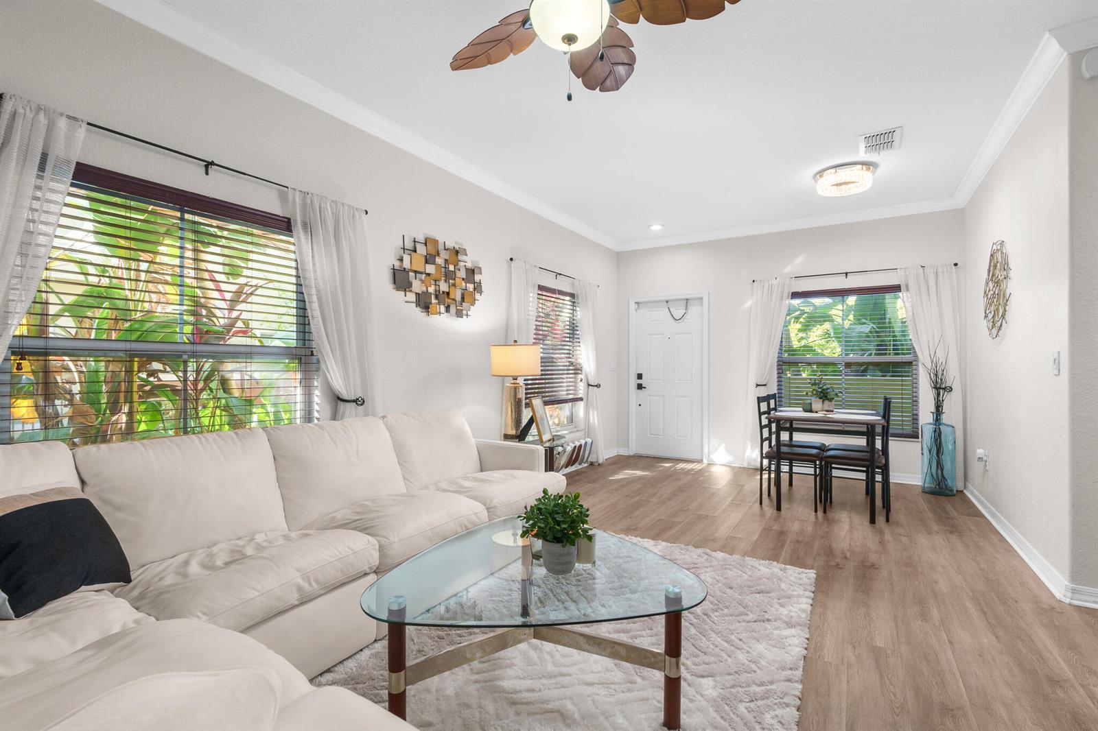 A living room features a white sectional sofa, glass coffee table, and a dining area — 155 Monterey Bay Drive, Boynton Beach FL 33426, BOYNTON BEACH, FL