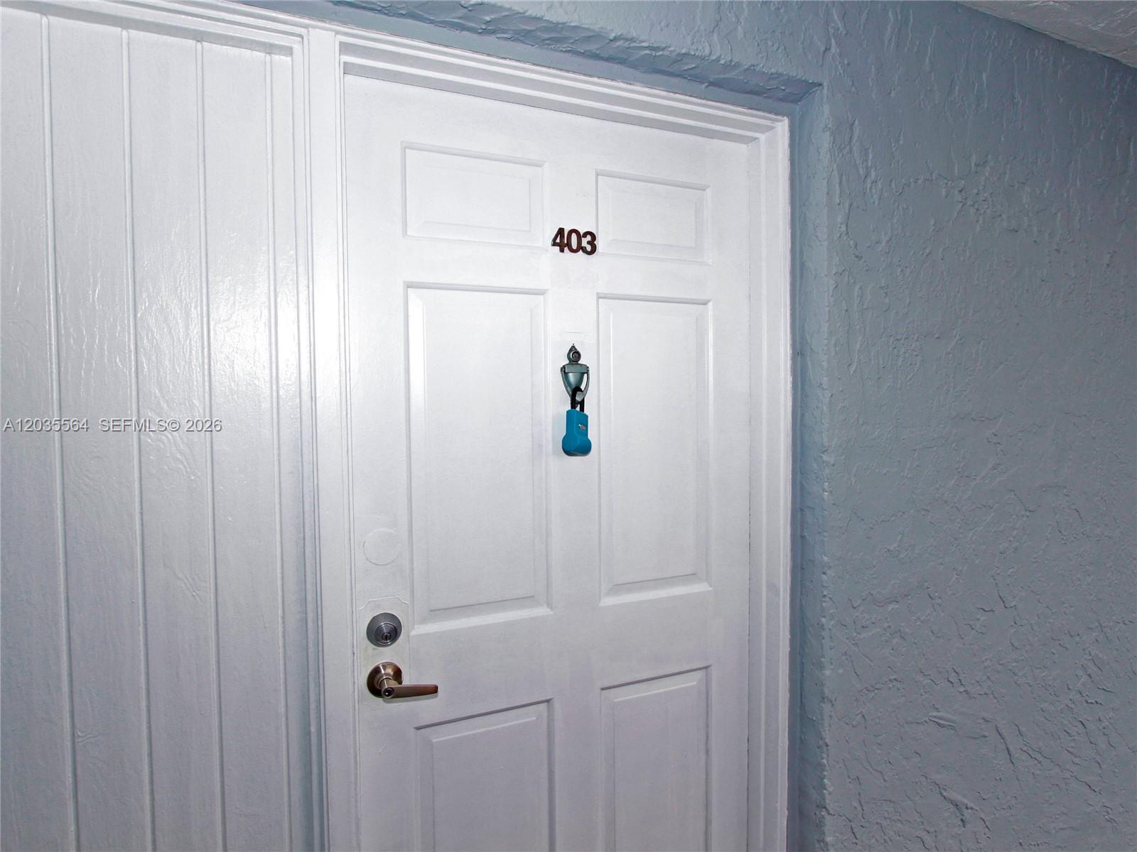 A white door marked with the number 403 features a blue lockbox and a knocker — 9351 Fontainebleau Blvd # B403, Miami FL 33172, MIAMI, FL