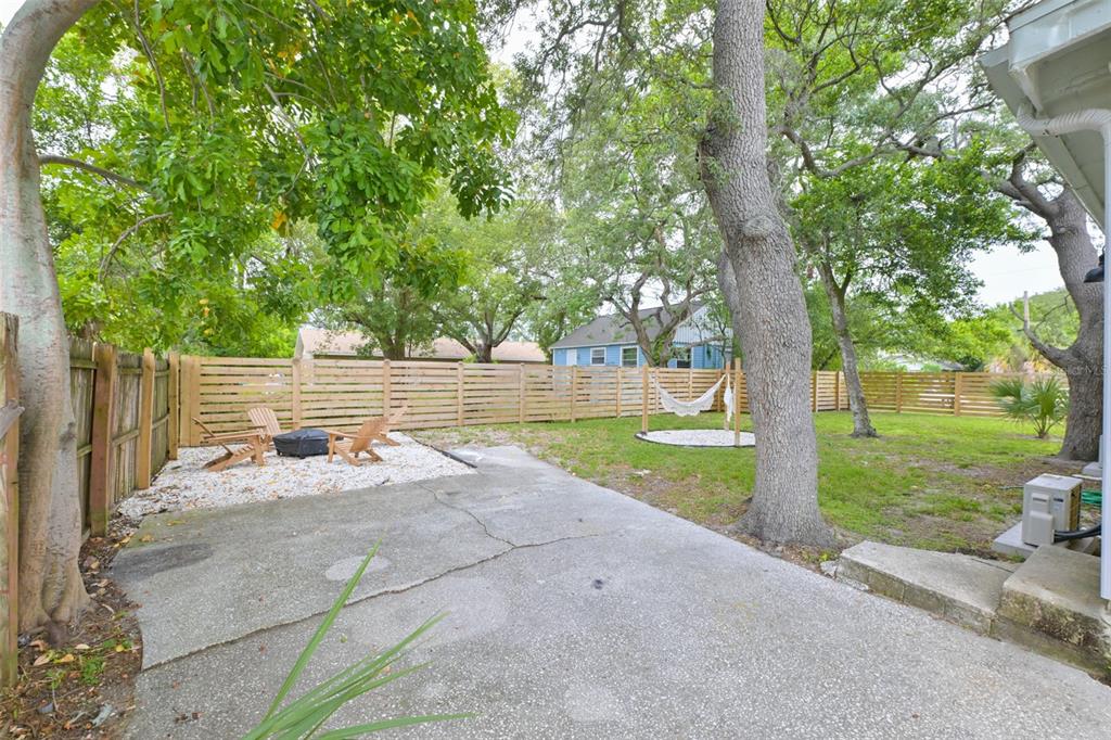 A backyard features a concrete patio, a gravel fire pit area, and a hammock — 1161 HOWARD STREET, CLEARWATER, FL